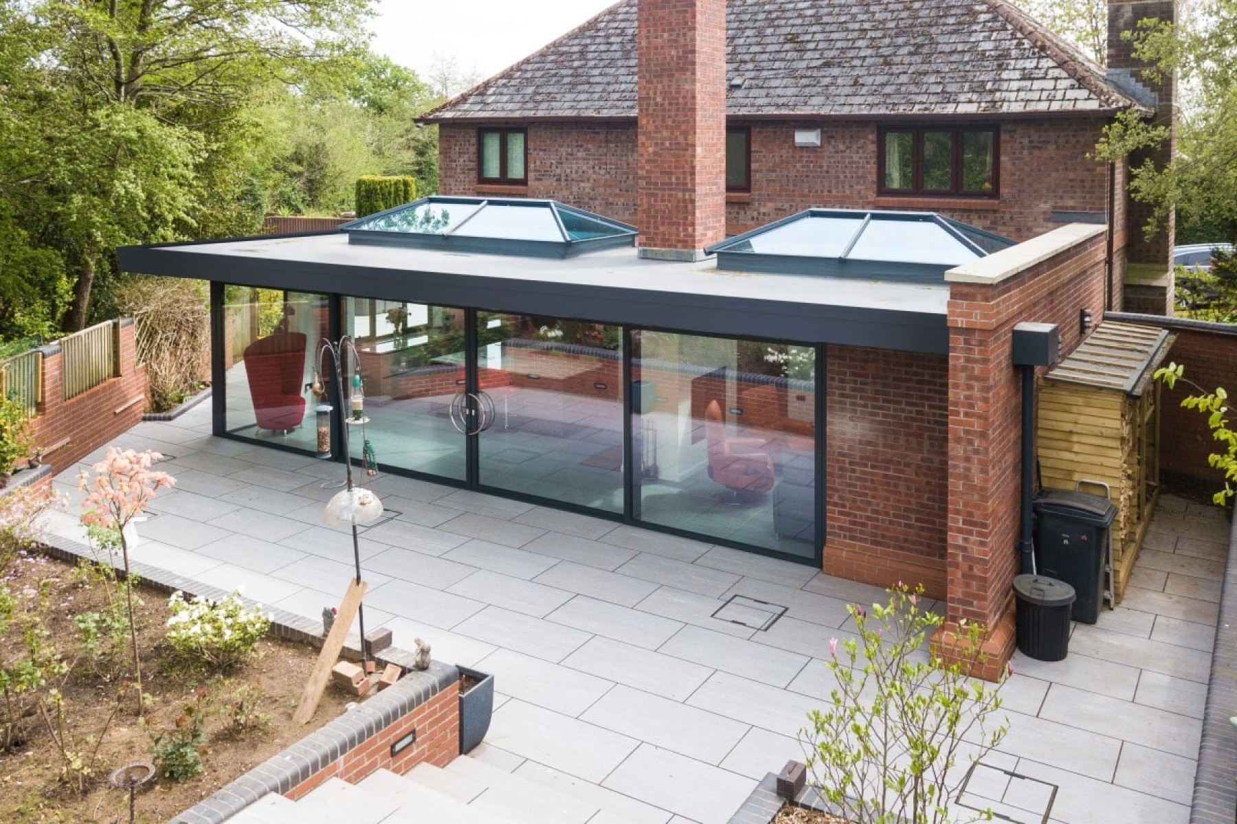 modern conservatory extension with two roof lanterns and a tiled patio from above
