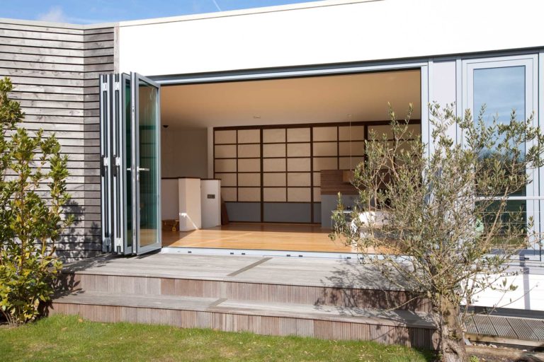 folded open bifolding doors leading to a patio and garden