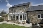 white upvc edwardian conservatory attached to an old stone house