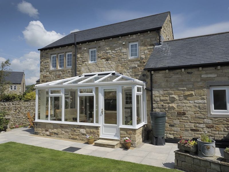 white upvc edwardian conservatory attached to an old stone house