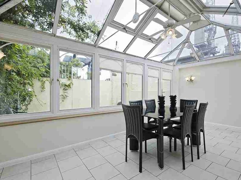 inside a white uPVC conservatory with a black table and chairs