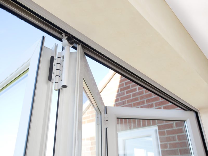 half open white bifold doors top threshold steel liner