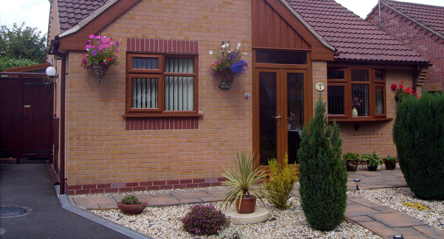 brown uPVC casement windows and French doors on a brick house