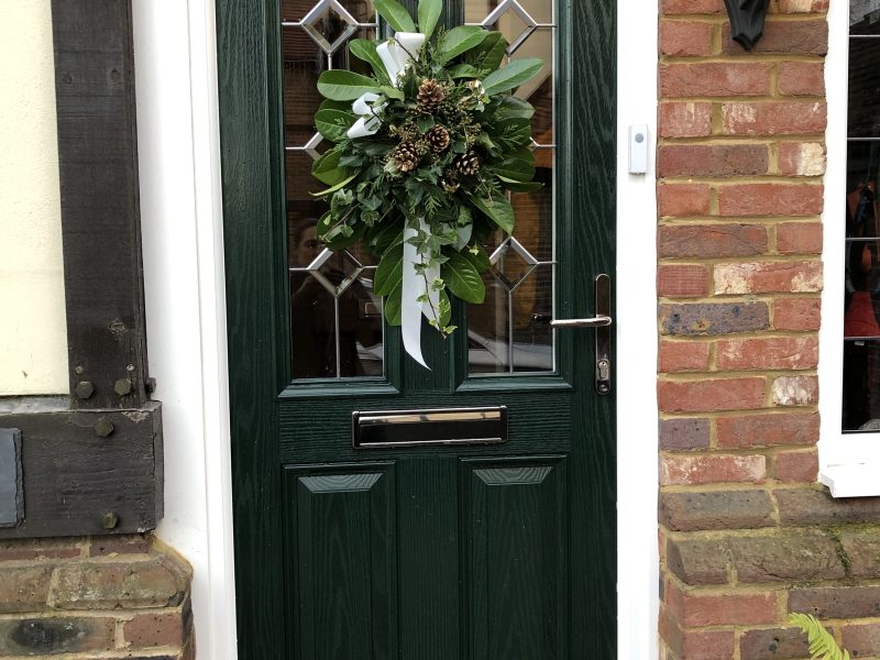 Dark green composite door with a Christmas door wreath
