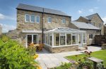 heritage stone home with a white uPC conservatory and French doors