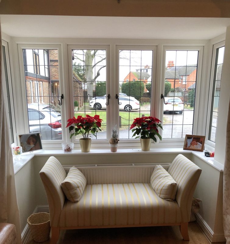 triple glazed white upvc bay window with a cream sofa in front