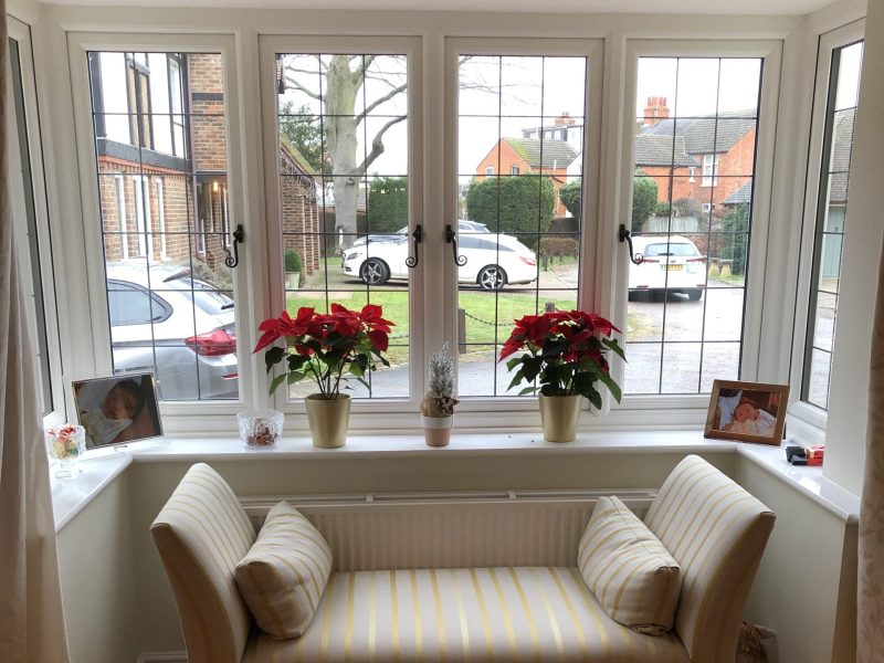 triple glazed white upvc bay window with a cream sofa in front