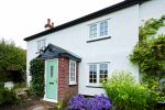 white home with a bright green composite door and Georgian bar casement windows