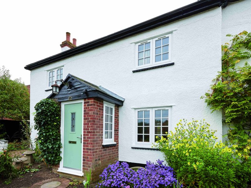 white home with a bright green composite door and Georgian bar casement windows
